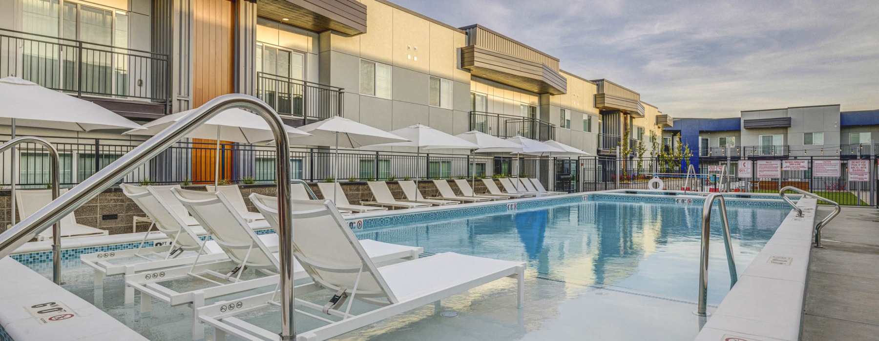 a courtyard with a pool and lounge chairs