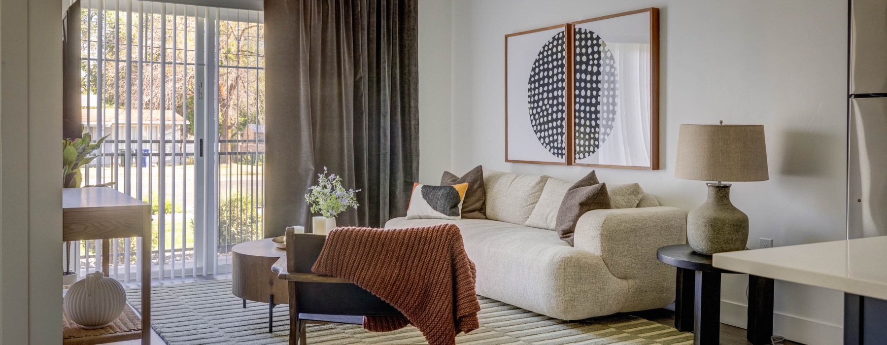a living room with a couch, tables and chair