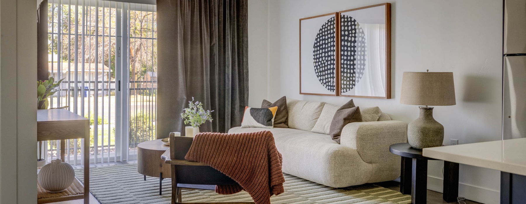a living room with a couch, tables and chair