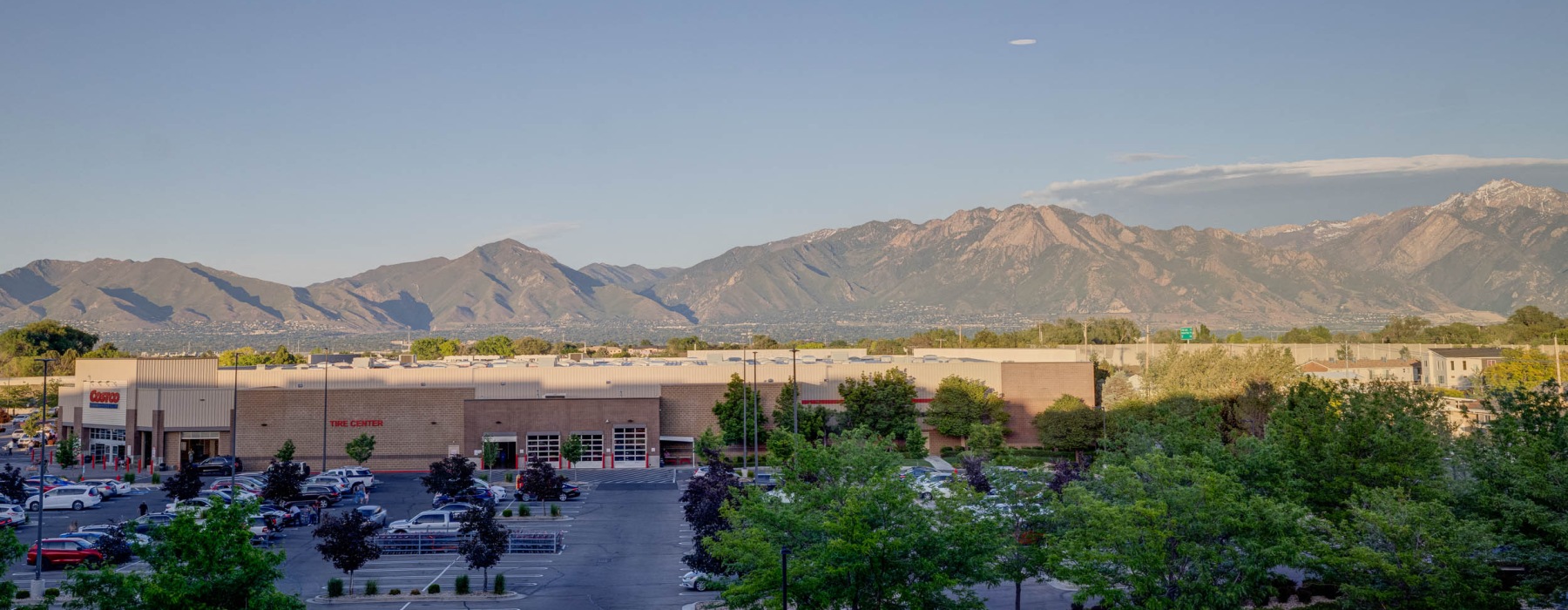 a parking lot with cars and mountains